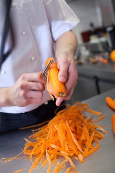 chef cuts fresh carrots in restaurant kitchen pre-beader ingredients eat food gastronomy work