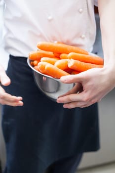 chef cuts fresh carrots in restaurant kitchen pre-beader ingredients eat food gastronomy work