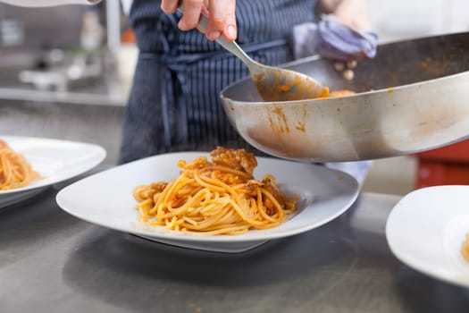 chef prepares fresh pasta spaghetti with shrimp crusts on a plate at the restaurant