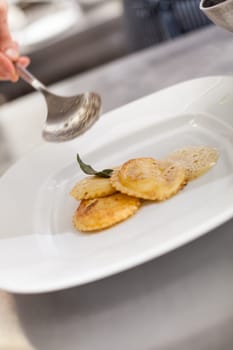 homemade stuffed ravioli with planed black truffle preparation in the restaurant kitchen