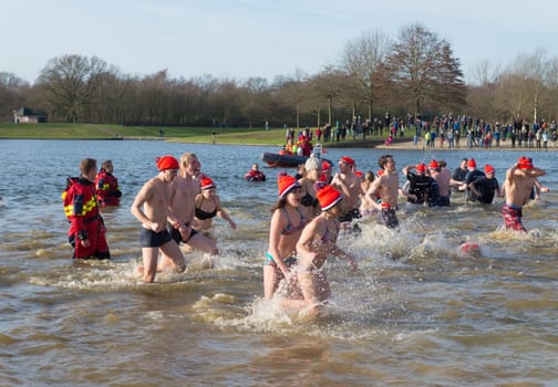 Traditional new years dive in Wierden, Netherlands. Each year there are over 200 locations in the country where people can take a dive in the ice cold water on january 1.