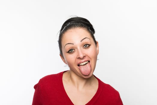 Portrait of beautiful caucasian woman wearing red dress and sticking tongue out