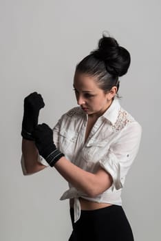 Fashion portrait of beautiful caucasian female model wearing white shirt and wearing fingerless gloves
