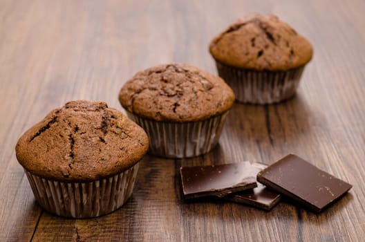 Three muffins and chocolate on one table