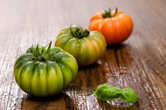 Italian ox heart tomatoes with basil on a wooden table