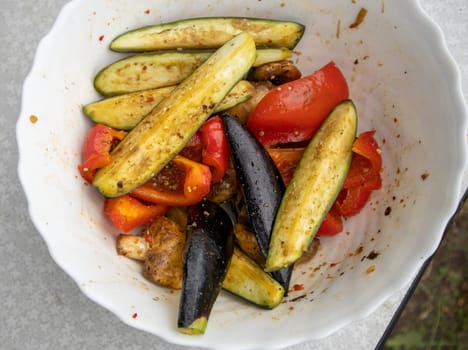 Grilled vegetables -bell peppers, zucchini, eggplant on a white plate, top view, close-up.