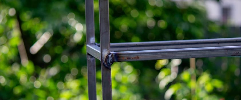 a man paints metal with black paint with a brush. Selective focus