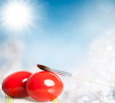 Easter eggs and paint brush on spring bokeh background