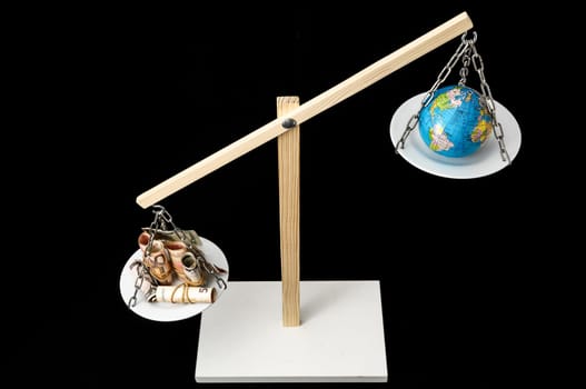 Globe Planet Earth and Money on a Two Pan Balance