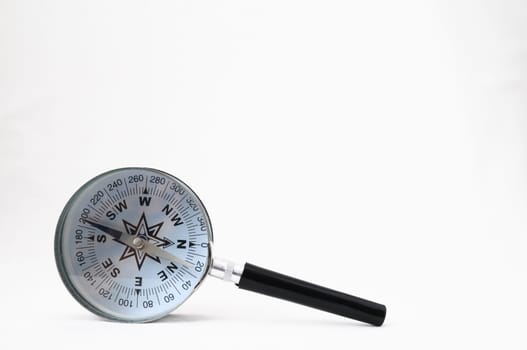 Orientation Concept - Analogic Compass and Loupe on a White Background