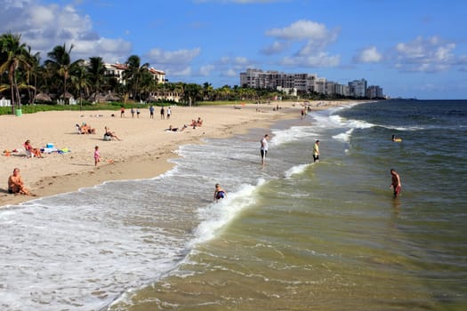 LAUDERDALE-BY-THE-SEA, FLORIDA - SEPTEMBER 21, 2013: Many people relaxing on the island shores on a beautiful and sunny blue sky day in this well visited small tropical city of 6,258 people in 2012.