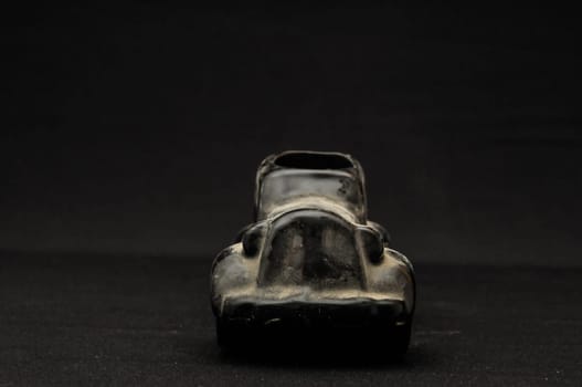 Vintage Old Ceramic Black Car on the Dark background