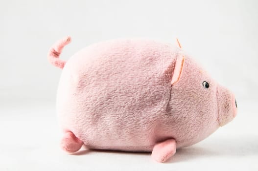 The pink pig cloth figurine on a white background
