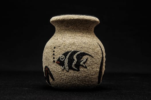 Colorful designed clay vase over a Black background