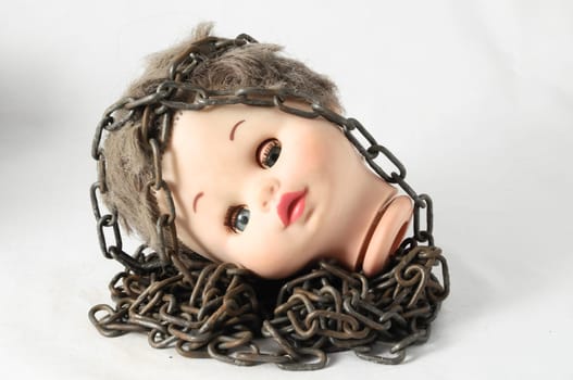 Vintage Plastic Scary Doll Head and Chain on a White Background