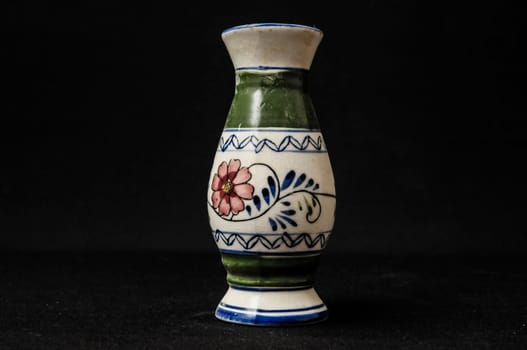 Colorful designed clay vase over a Black background