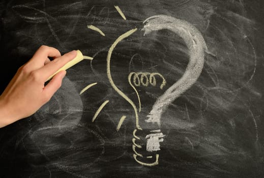Hand drawing a light bulb to a question mark,idea concept