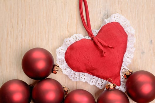 Red Christmas baubles on a wooden background with space for your text