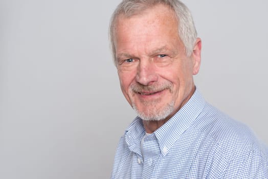 Portrait of a senior against a grey background