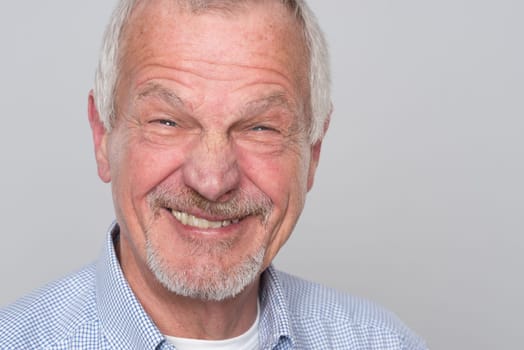 Portrait of a senior against a grey background