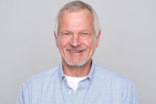Portrait of a senior against a grey background