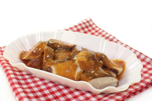 a currywurst with fries and salad