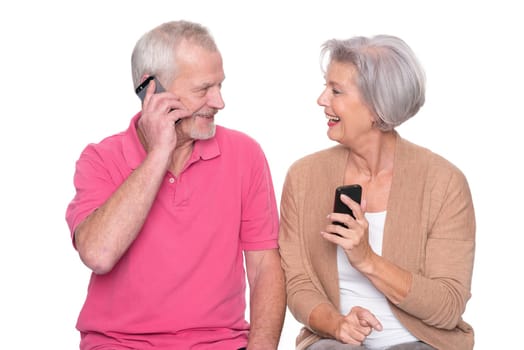 Senior couple with smartphone against a white background