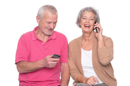 Senior couple with smartphone against a white background