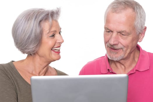 Senior couple with computer against a white background