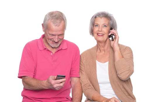Senior couple with smartphone against a white background