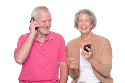 Senior couple with smartphone against a white background