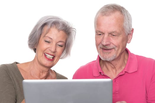Senior couple with computer against a white background