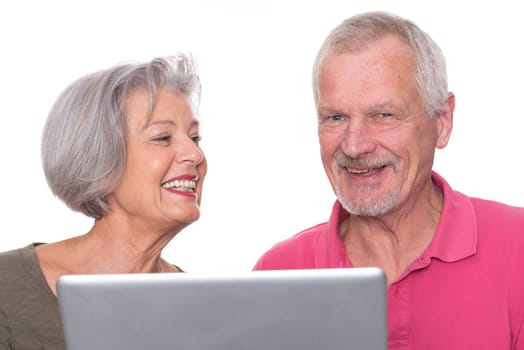 Senior couple with computer against a white background