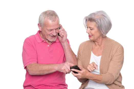 Senior couple with smartphone against a white background