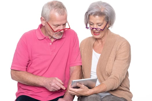 Senior couple with tablet against a white background