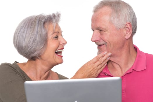 Senior couple with computer against a white background