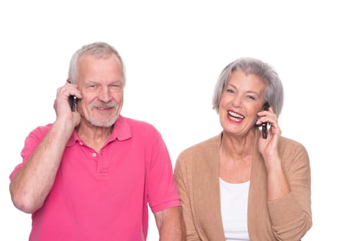 Senior couple with smartphone against a white background