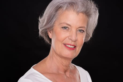 Portrait of a senior woman against a black background