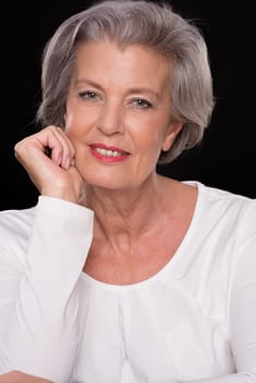 Portrait of a senior woman against a black background