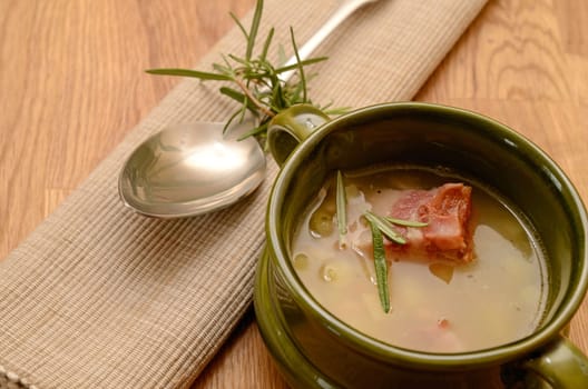 Green bowl with bean soup and bacon
