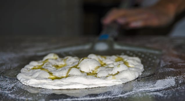 Handling, working and cooking pizza dough with shovel