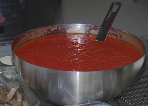 Steel recipient with tomato sauce ready for red pizzas