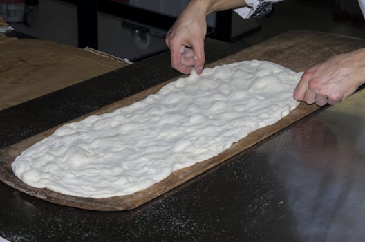 Handling, working and cooking pizza dough with shovel