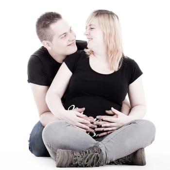Happy young pregnant couple in the studio