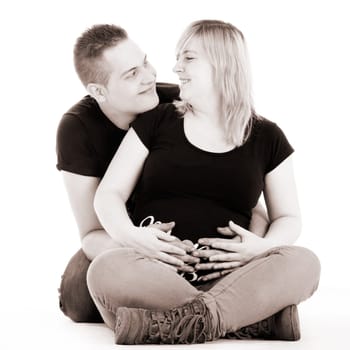 Happy young pregnant couple in the studio