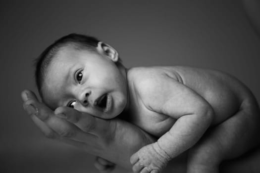 happy newborn baby girl just a week old photographed in the studio