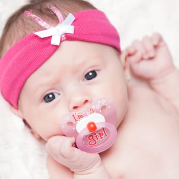 happy newborn baby girl just a week old photographed in the studio
