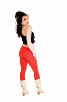 A pretty woman in a black top and red tights standing from the back.in boots for white background..