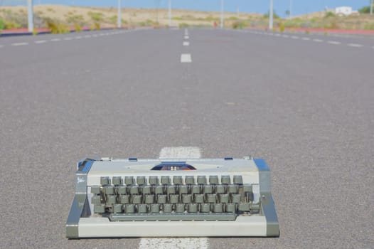 On the Road Writing Concept Typewriter over an Asphalt Street