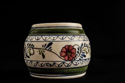 Colorful designed clay vase over a Black background